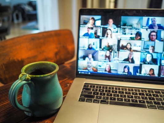 people on a video conference meeting with a cup of coffee beside a laptop